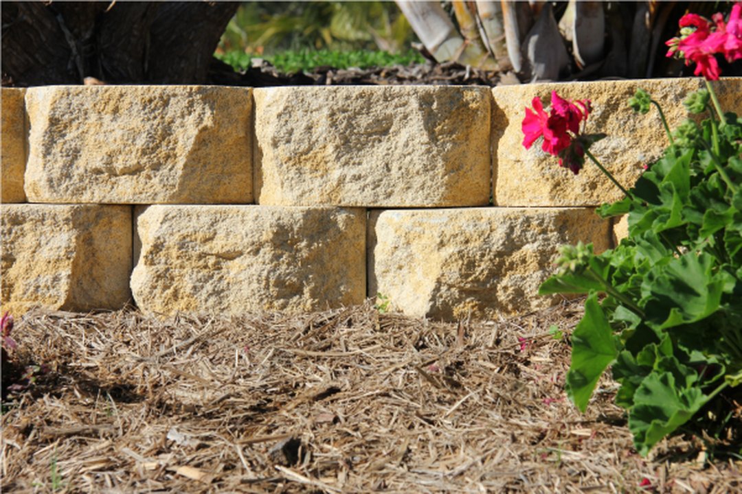 Apex Classic Wall Block Gold Blend retaining wall in garden landscape setting with split-face sandstone finish