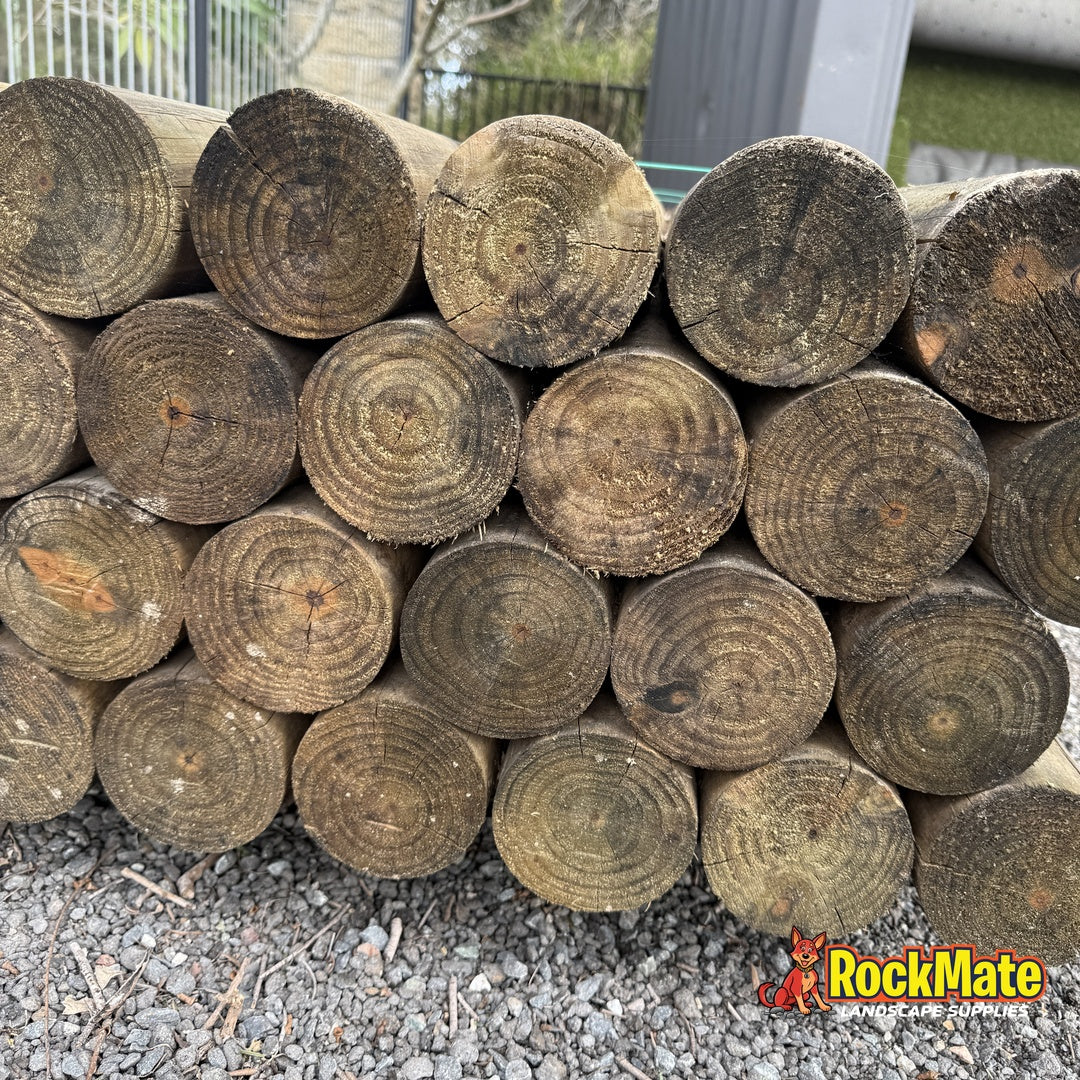Stack of 2.4m H4 treated pine round logs ready for delivery